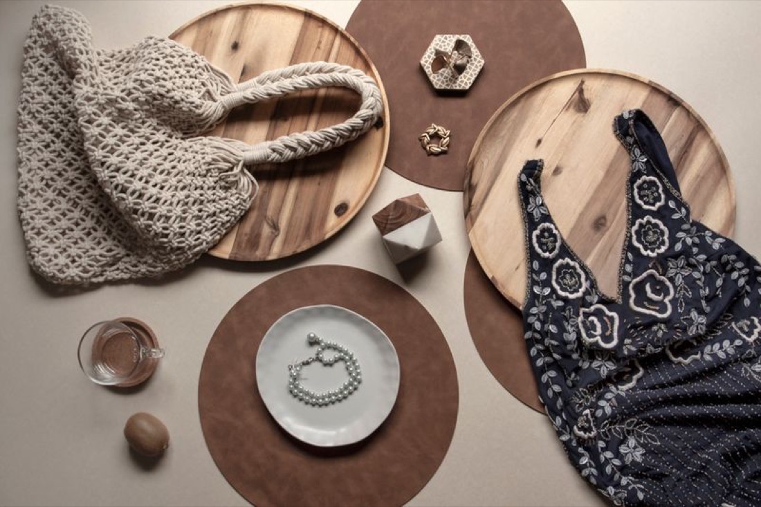 Flat lay of a crochet bag, bandana top, bracelets and wooden trays