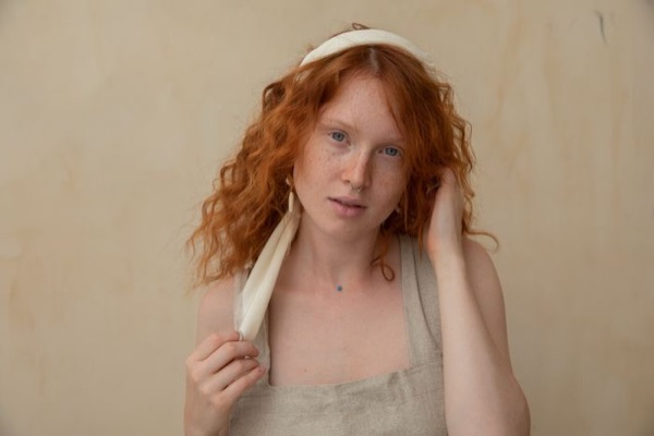 Portrait of a red-haired woman in a linen top