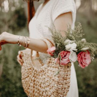 Woven straw market bag filled with flowers